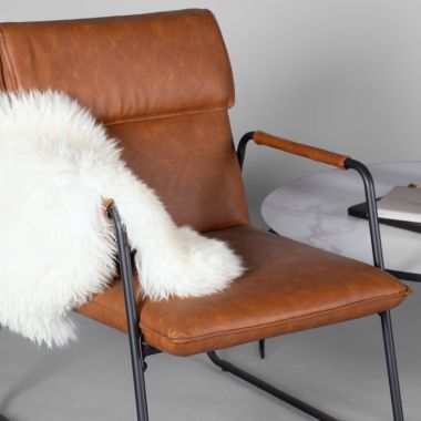 contemporary leather chair with sheepskin throw