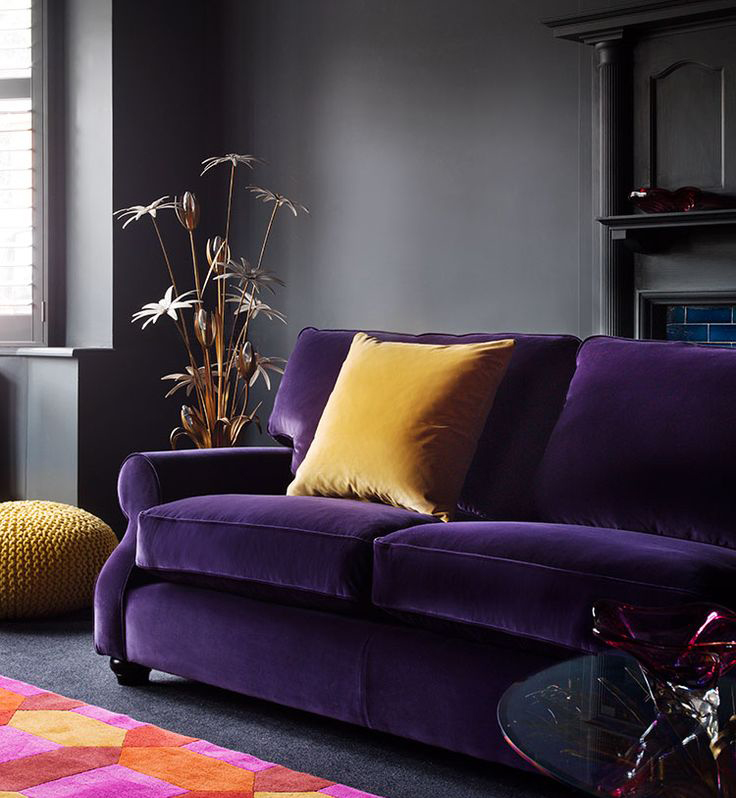 image of a purple velvet sofa with a golden yellow cushion
