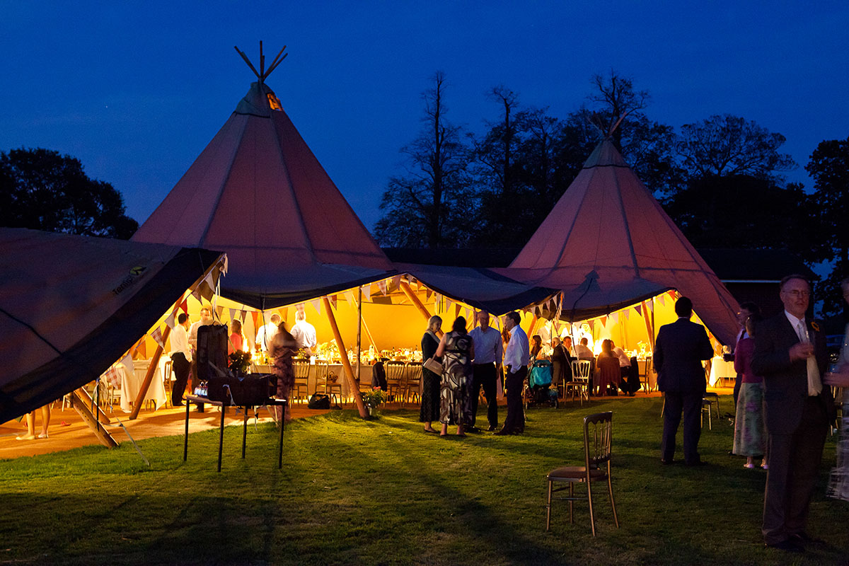 image of teepee style tents with people talking at an event