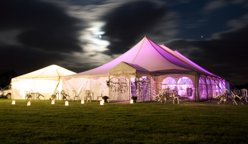 image of an white outdoor marquee in the night with purple lighting