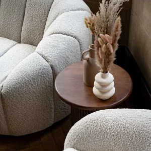 Creamy white soft boucle sofa with a wooden side table for event hire